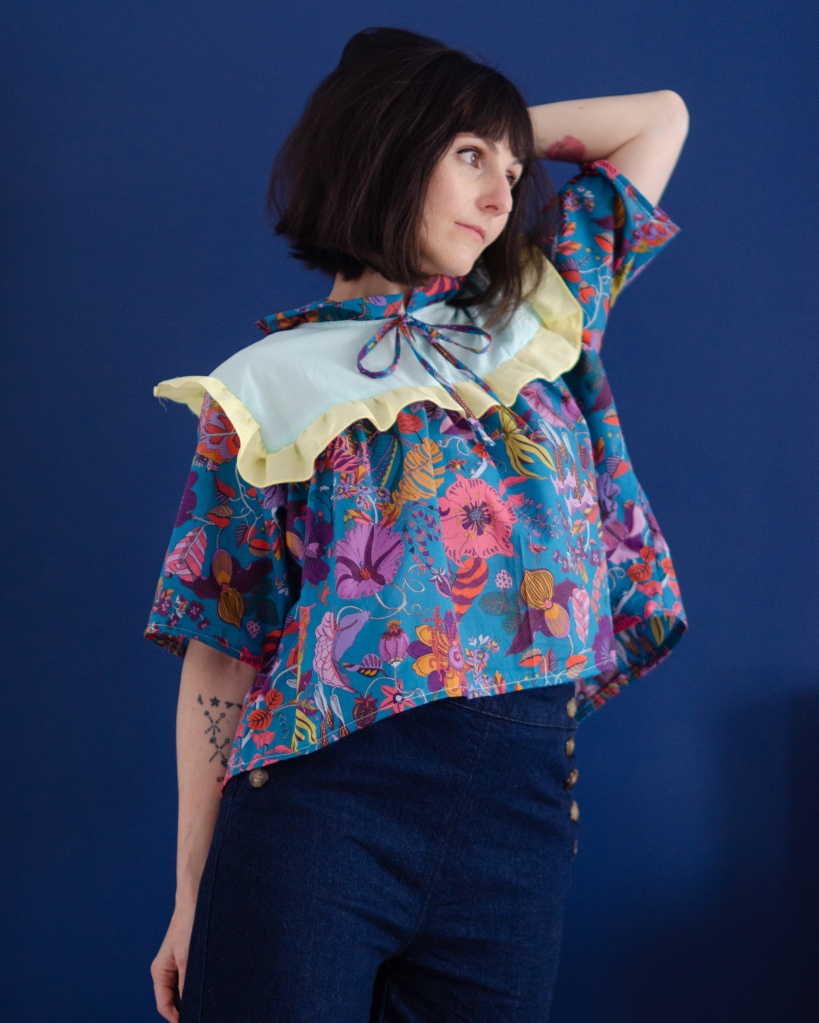 Front view of the mariposa blouse showing Liberty Tana lawn fabric, bust ruffle and neckline strings.
